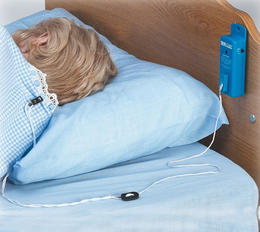 Magnetic pull string alarm for beds for caregivers